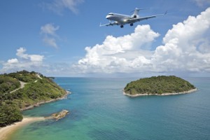 Private jet plane is going to land at the airport of a tropical island. Luxury style living concept.